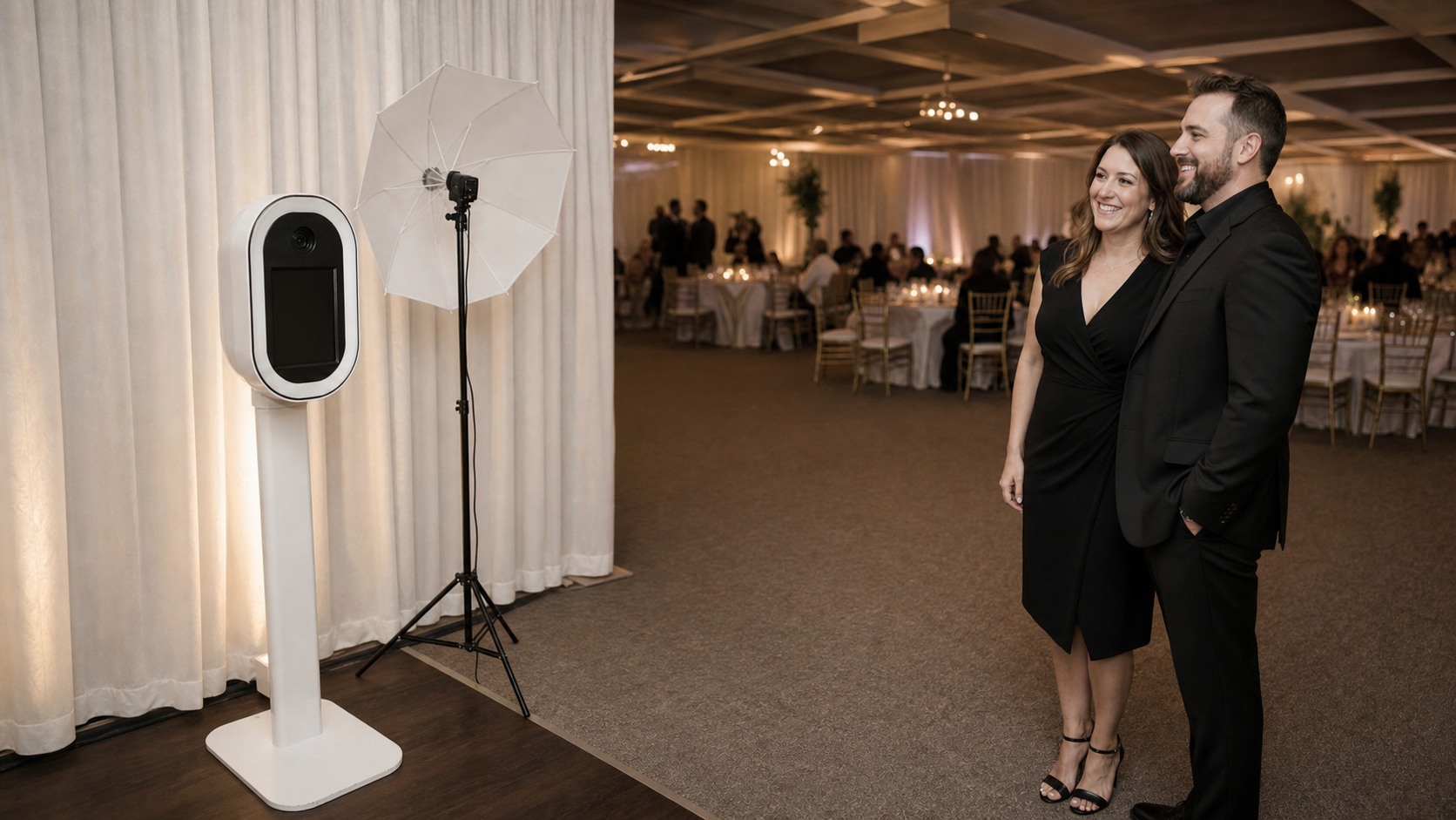 Pareja posando de perfil frente a una máquina de photobooth con iluminación profesional y fondo de evento